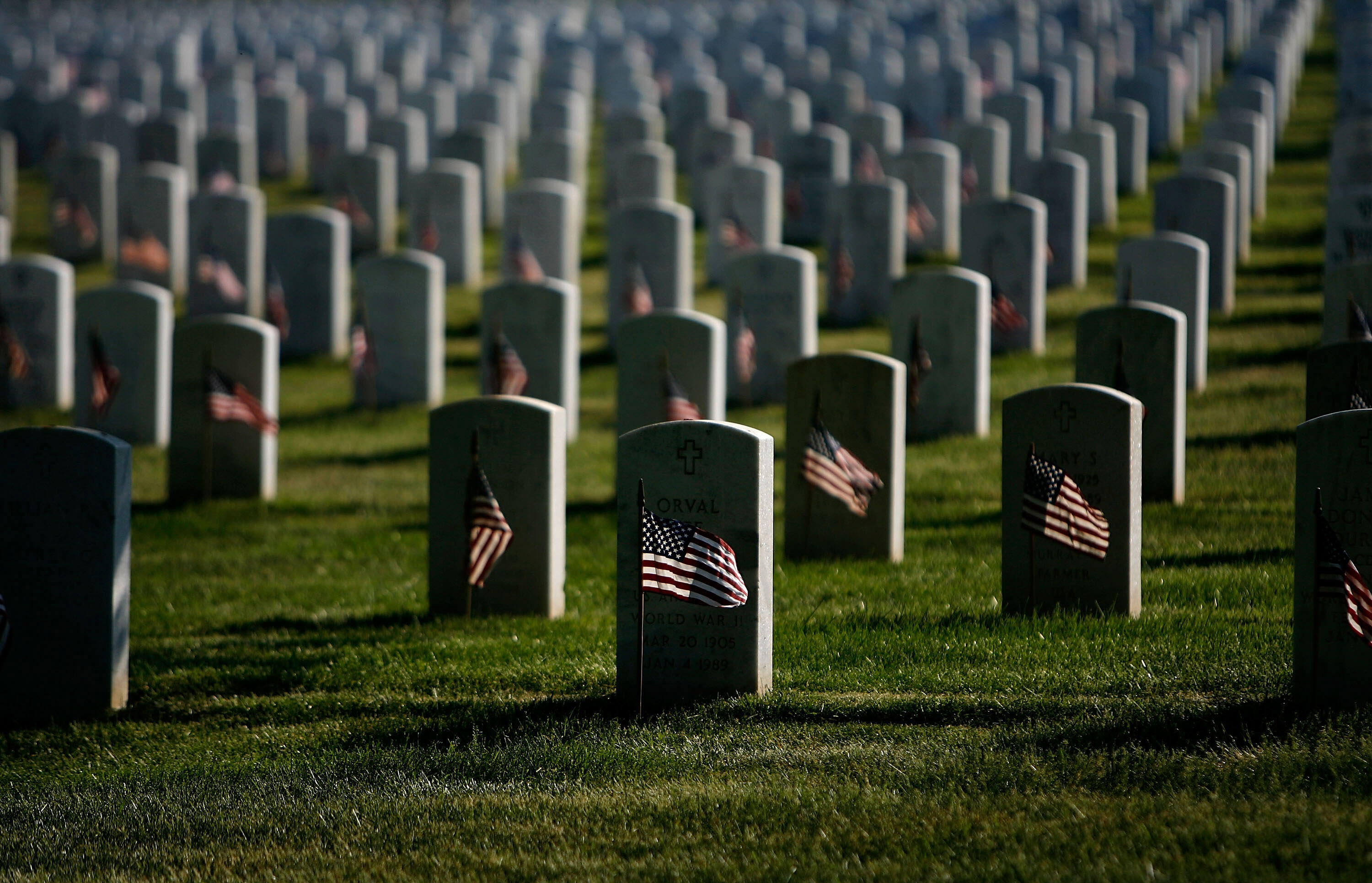 ARLINGTON, VA - MAY 24:  Small US flags wave in the wind after being placed in front of headstones at Arlington National Cemetery during the Flag-In Ceremony ahead of the Memorial Day weekend May 24, 2007 in Arlington, Virginia. It took approximately 3 hours for 1,300 soldiers, sailors and marines to put more than 300,000 flags in front of each of the gravestones at Arlington National Cemetery.  (Photo by Chip Somodevilla/Getty Images)