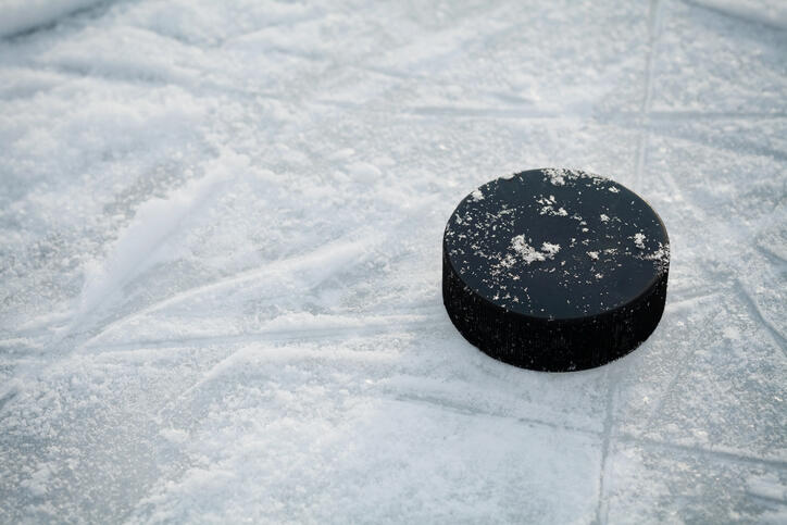 Hockey puck on ice hockey rink on shiny winter day