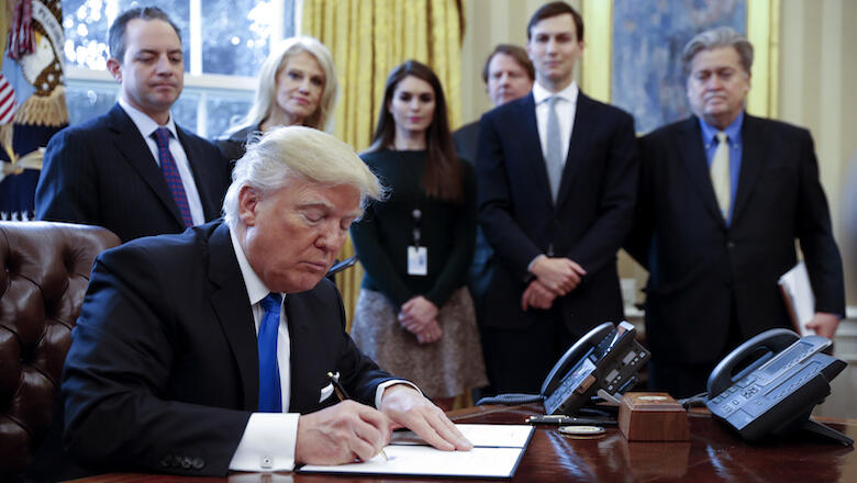WASHINGTON, DC - JANUARY 24: President Donald Trump signs one of five executive orders related to the oil pipeline industry in the Oval Office of the White House January 24, 2017 in Washington, DC. Looking on are White House Chief of Staff Reince Priebus,