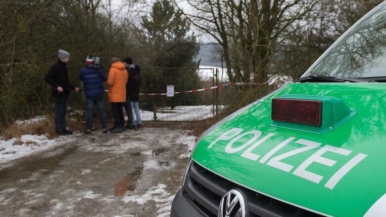 A police car and journalists stand in front of the fence blocking the access to the private property where six teenagers were found dead in Arnstein, central Germany, on January 30, 2017. Six teenagers were found dead Sunday after holding a party in a gar