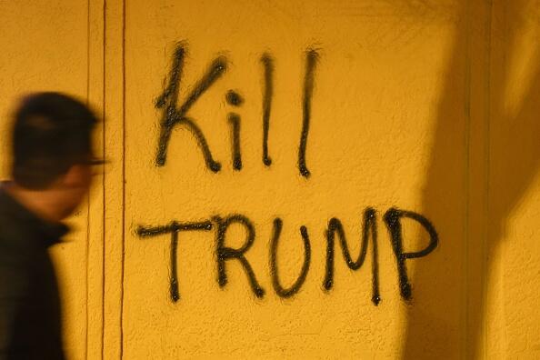 A man looks at graffiti during a protest in Berkeley, California on February 1, 2017.  Violent protests erupted on February 1 at the University of California at Berkeley over the scheduled appearance of a controversial editor of the conservative news website Breitbart. / AFP / Josh Edelson        (Photo credit should read JOSH EDELSON/AFP/Getty Images)