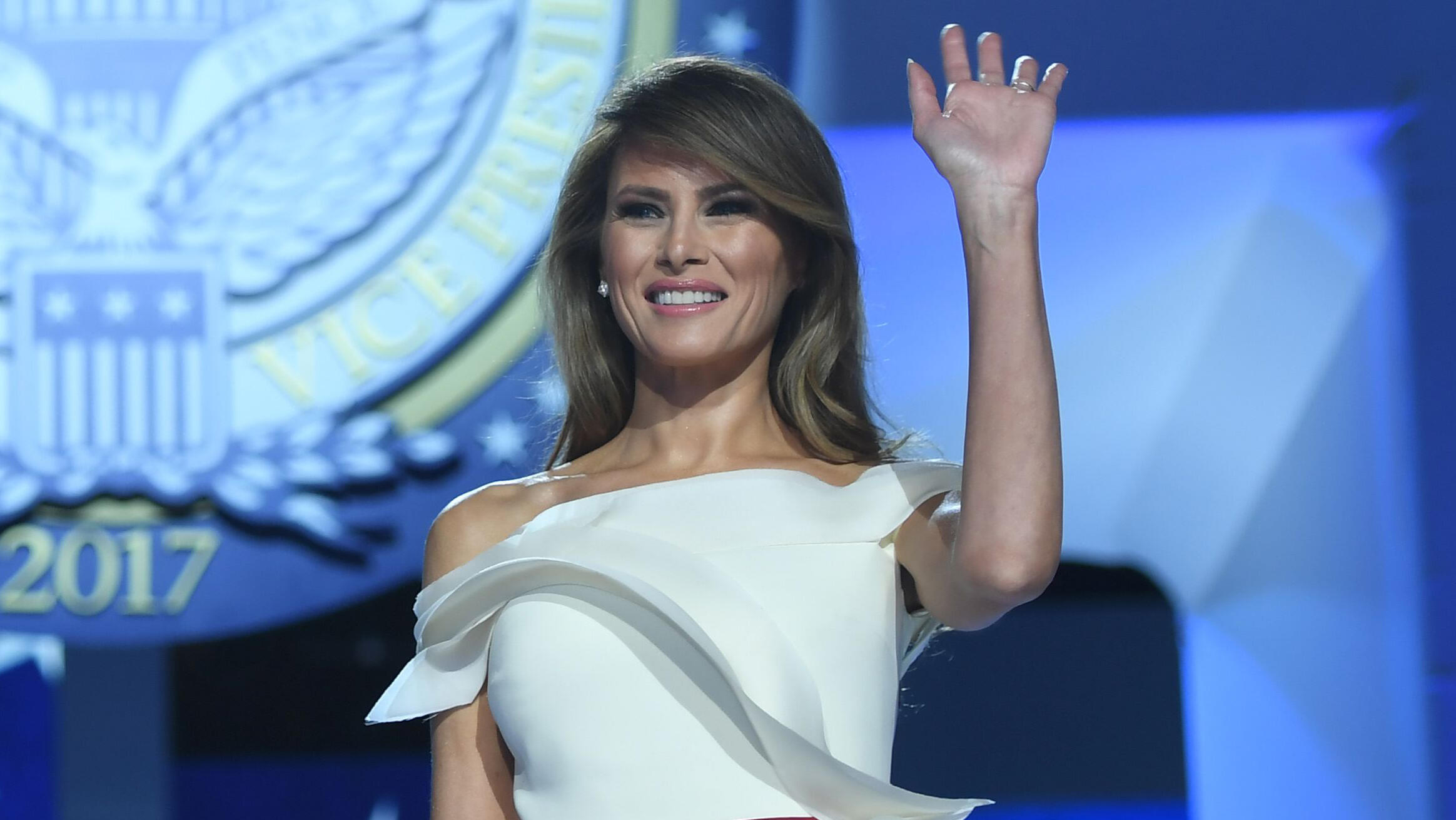 US President Donald Trump looks on as first lady Melania Trump waves during the Freedom Ball at the Washington DC Convention Center following Donald Trump's inauguration as the 45th President of the United States, in Washington, DC, on January 20, 2017.  
