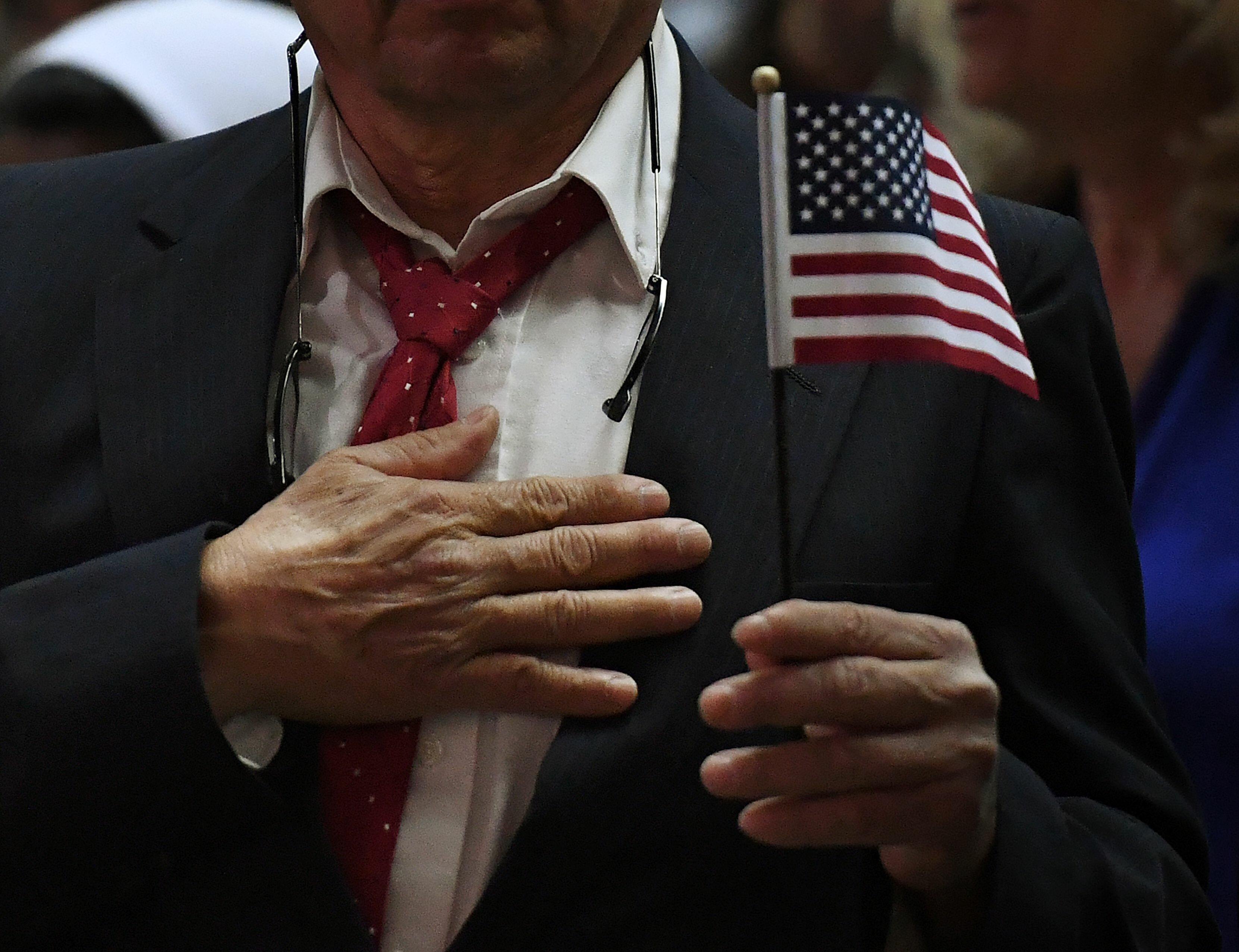 A man pledges allegiance to the United States of America to become a US citizenship at a naturalization ceremony for immigrants in Los Angeles, California, on February 15, 2017. Curbing immigration, as US President Donald Trump appears intent on doing, co