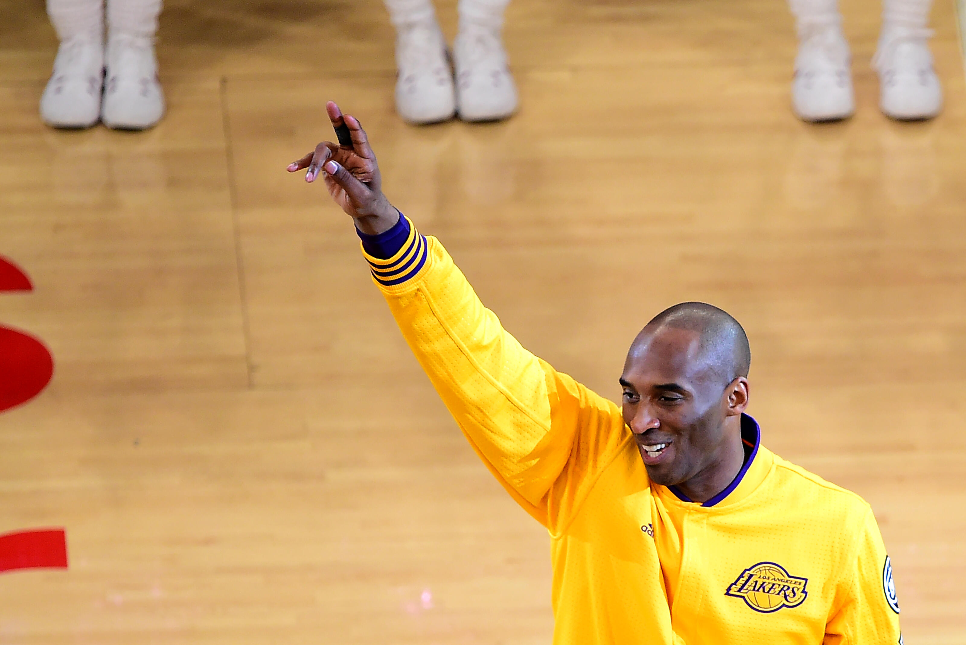Kobe Bryant of the Los Angeles Lakers gestures to fans ahead of his final game as a Laker in their season-ending NBA western division matchup aainst the Utah Jazz in Los Angeles, California on April 13, 2016. / AFP / FREDERIC J. BROWN        (Photo credit
