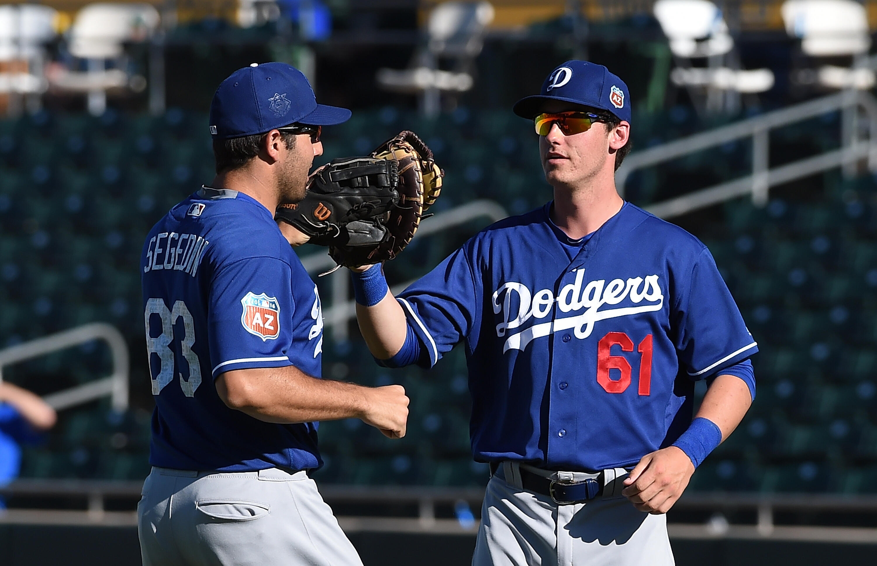 MESA, AZ - MARCH 10:  Rob Segedin #83 and teammate Cody Bellinger #61 of the Los Angeles Dodgers celebrate an 8-3 win against the Oakland Athletics at HoHoKam Stadium on March 10, 2016 in Mesa, Arizona.  (Photo by Norm Hall/Getty Images)