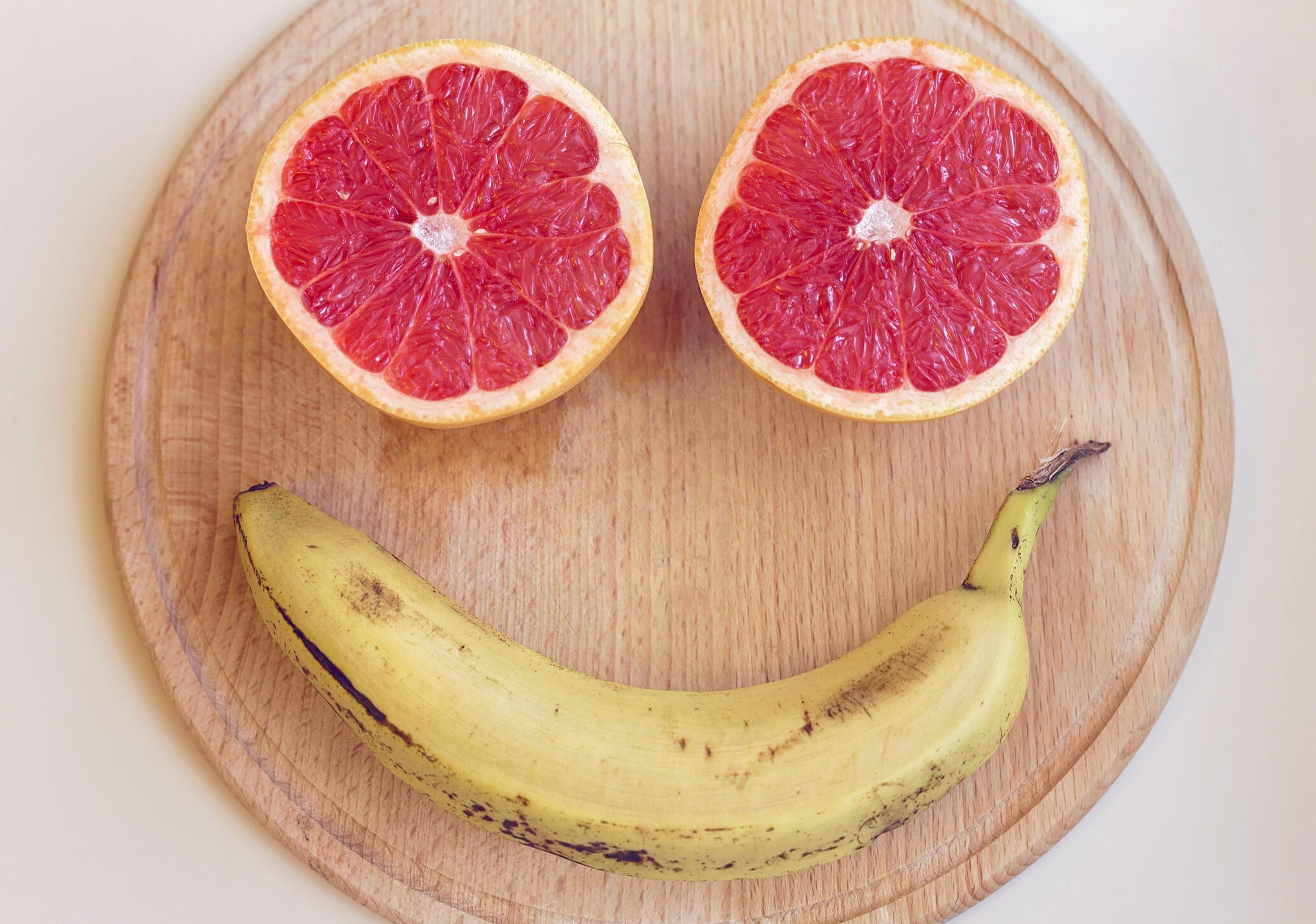 Smiling face made from fruit on a wooden background
