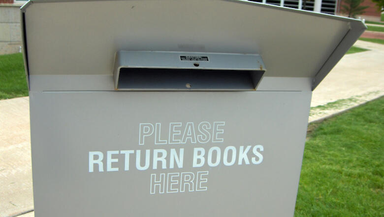 A metal book return bin outside a university library.