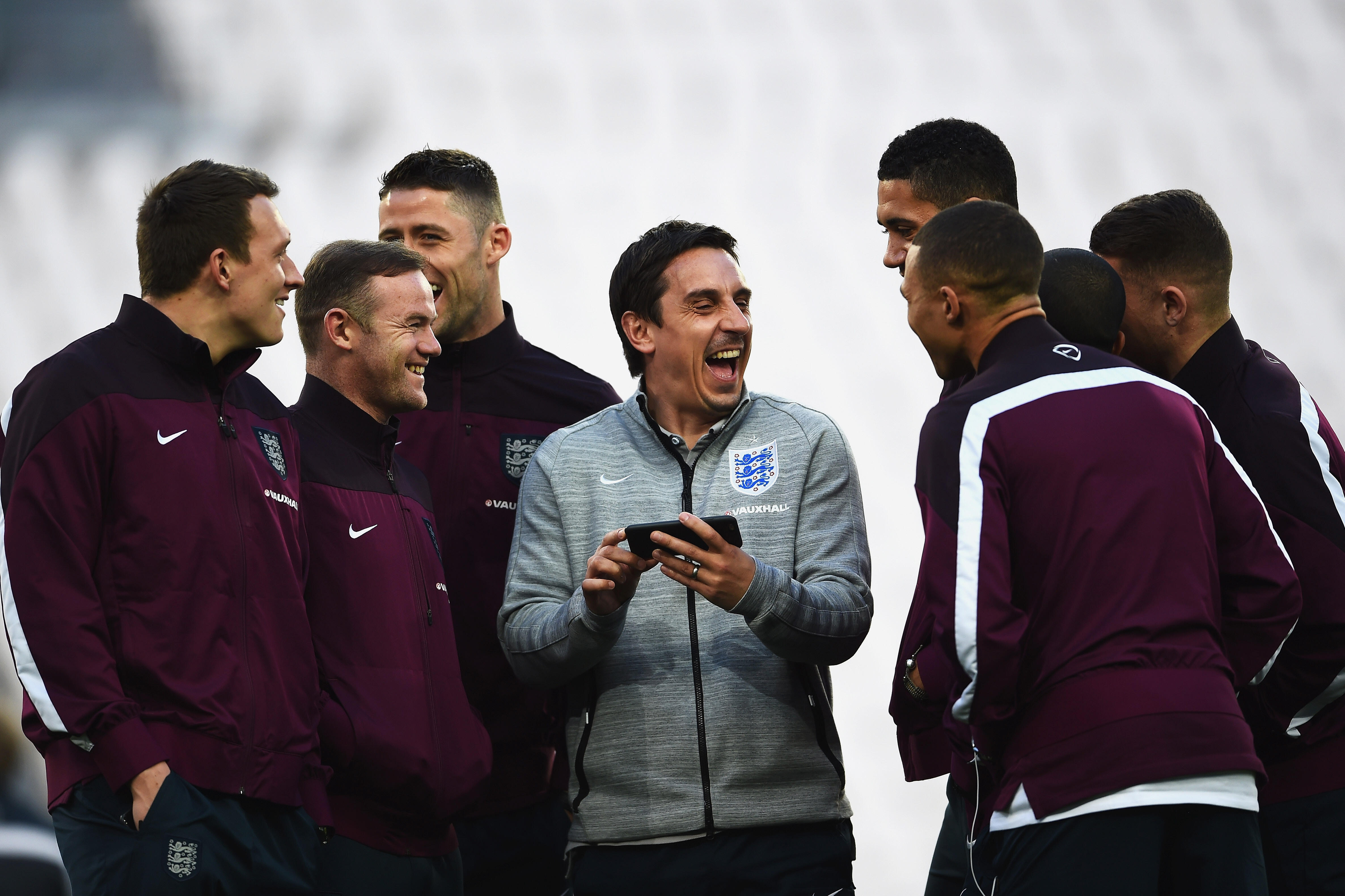 TURIN, ITALY - MARCH 30: First Team Coach Gary Neville of England laughs with England players including Phil Jones (L) and Wayne Rooney (2ndL) during an England team stadium visit ahead of the International Friendly match against Italy at Juventus Arena o
