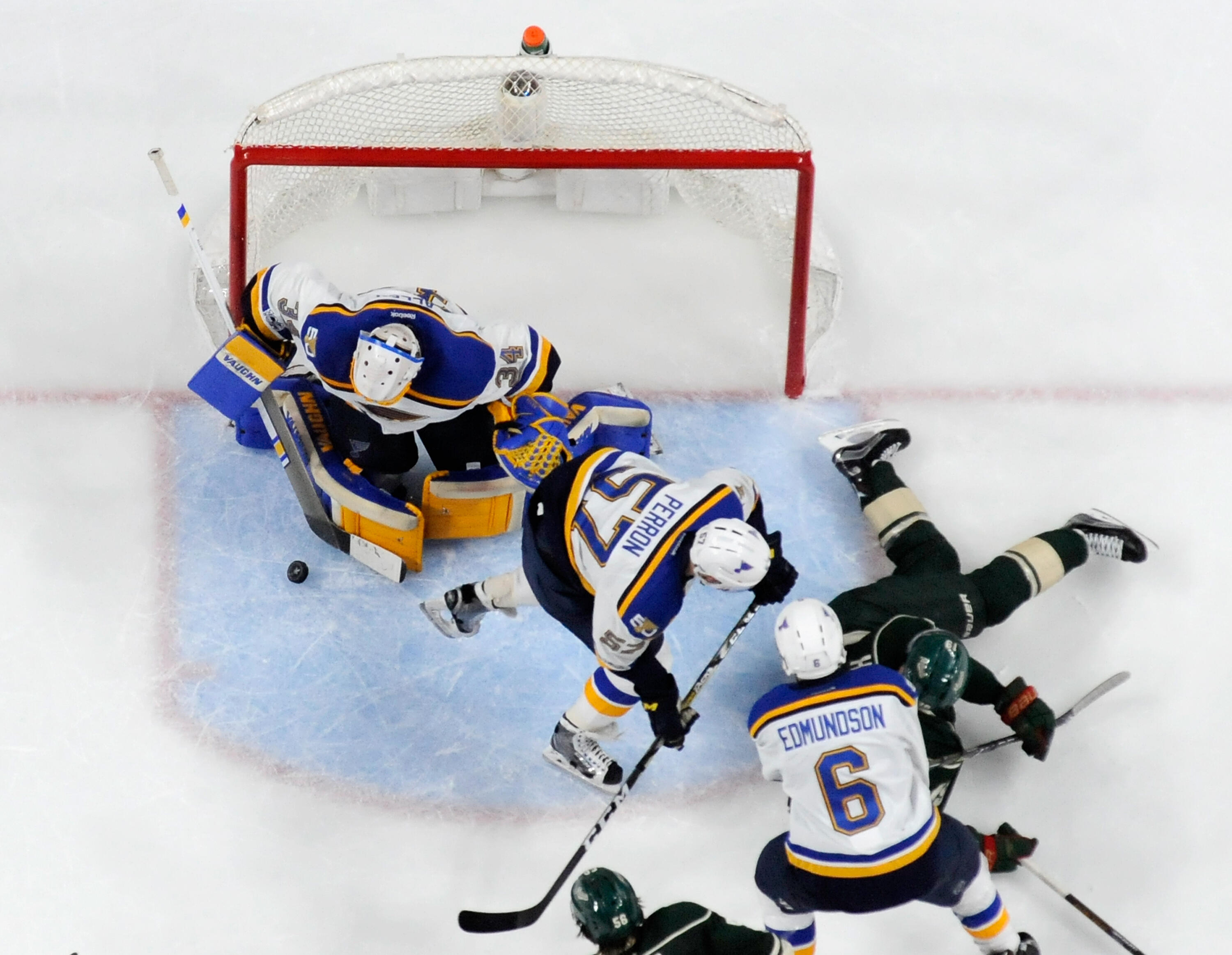 ST PAUL, MN - APRIL 14: Jake Allen #34 of the St. Louis Blues makes a stick side save of a shot by Martin Hanzal #19 of the Minnesota Wild as teammate David Perron #57 and Joel Edmundson #6 look on during the third period in Game Two of the Western Confer