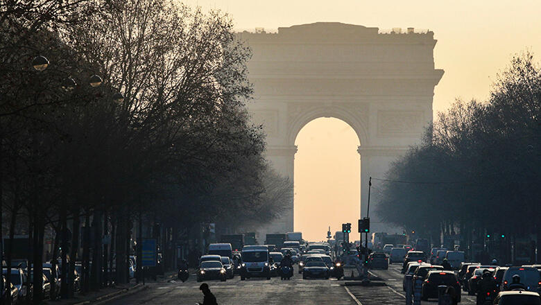 Motorists drive vehicles on the first day of anti-pollution restrictive driving measures, next to the Arc de Triomphe in Paris, on January 23, 2017. Only one week after the introduction of the Crit'Air anti-pollution vignettes, Paris and Lyon will ban the