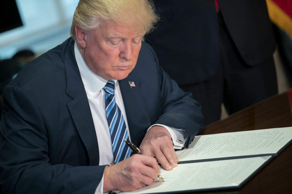 WASHINGTON, DC - APRIL 21: (AFP OUT) U.S. President Donald Trump signs a financial services Executive Order during a ceremony in the US Treasury Department building on April 21, 2017 in Washington, DC. President Trump is making his first visit to the Treasury Department for a memorandum signing ceremony with Secretary Mnuchin. (Photo by Shawn Thew - Pool/Getty Images)