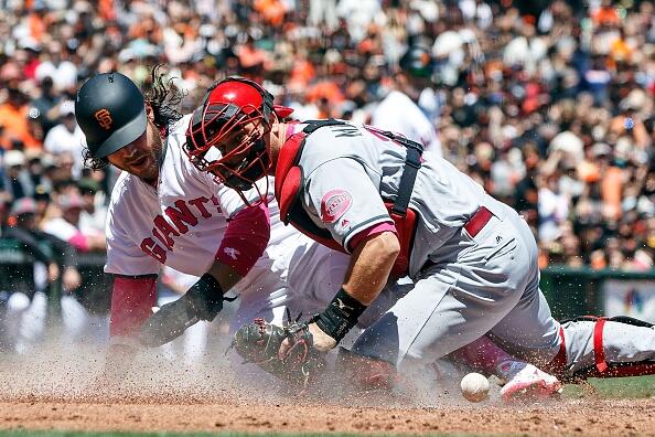 SAN FRANCISCO, CA - MAY 14: Brandon Crawford #35 of the San Francisco Giants scores a run ahead of a tag from Devin Mesoraco #39 of the Cincinnati Reds during the first inning at AT&T Park on May 14, 2017 in San Francisco, California.  Players are wearing pink to celebrate Mother's Day weekend and support breast cancer awareness. (Photo by Jason O. Watson/Getty Images)