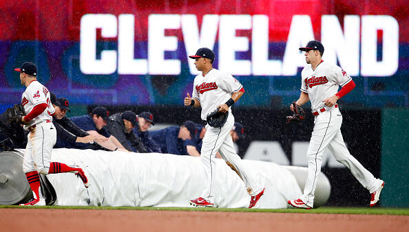 CLEVELAND, OH - MAY 24: Daniel Robertson #99 Michael Brantley #23 and Bradley Zimmer #4 of the Cleveland Indians run to the dugout as the grounds crew rolls out the tarp due to heavy rain against the Cincinnati Reds during the sixth inning at Progressive Field on May 24, 2017 in Cleveland, Ohio. (Photo by Ron Schwane/Getty Images)