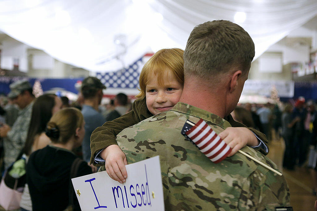 FORT CARSON, CO - NOVEMBER 4: Gavin Shaw, 5, flashes a smile as he hugs his father, Master Sergeant Adam Shaw, during a Welcome Home Ceremony for approximately 230 4th Brigade Combat Team soldiers, November 4, 2012 in Fort Carson, Colorado. The soldiers h