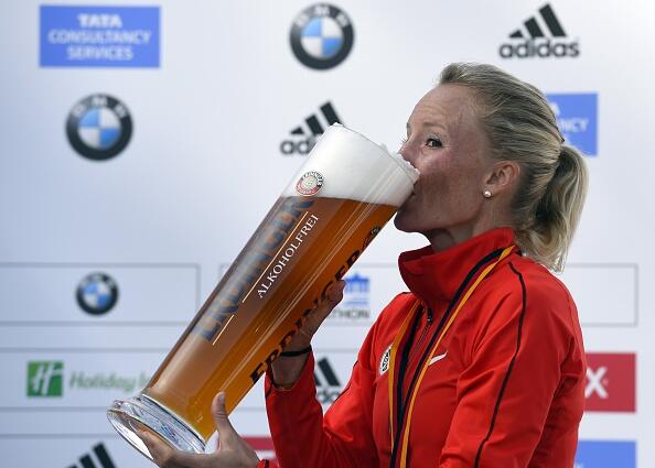 Third placed Shalane Flanagan of US drinks beer on the podium after the 41th edition of the Berlin Marathon in Berlin on September 28, 2014. AFP PHOTO / TOBIAS SCHWARZ        (Photo credit should read TOBIAS SCHWARZ/AFP/Getty Images)