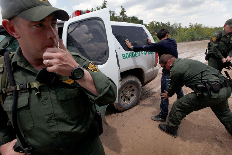 MCALLEN, TX - MAY 27:  A Border Patrol agent searches an undocumented immigrant apprehended near the Mexican border on May 27, 2010 near McAllen, Texas. The man was captured with several other immigrants including two young children in thick brush after c