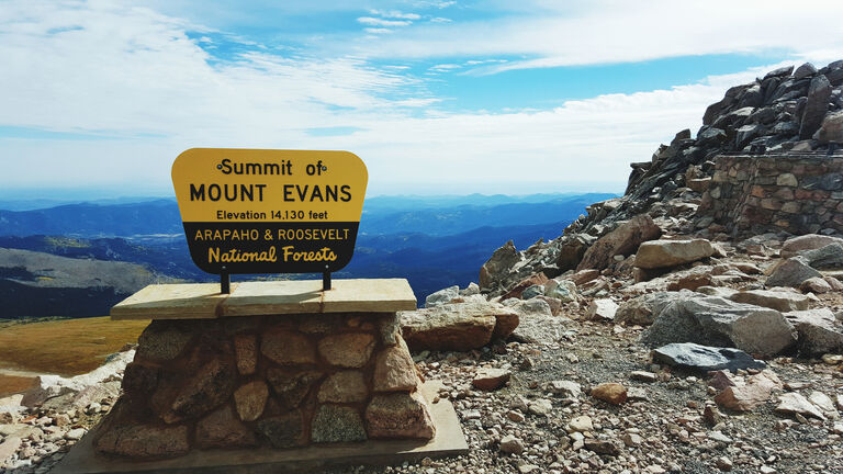 Close-Up Of Information Sign On Rock Against Sky