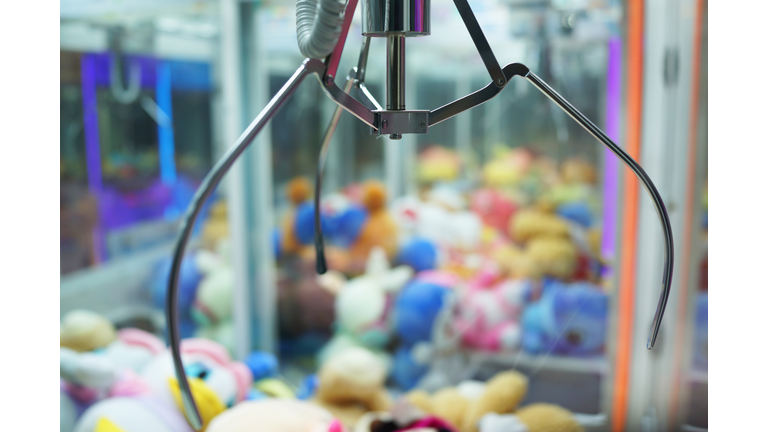 Close up of the doll claw machine of games arcade in shopping mall