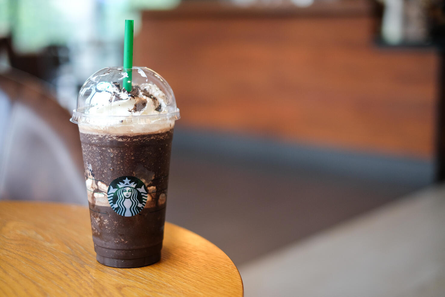 Bangkok, Thailand - May 22, 2018 : "Midnight mocha frappe" with whipped cream & powder coffee on brown table & Starbucks coffee sign.