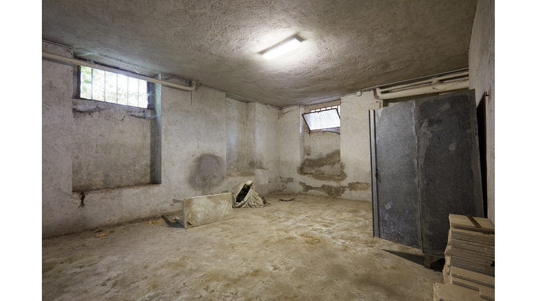 Messy basement with broken furniture in old house interior