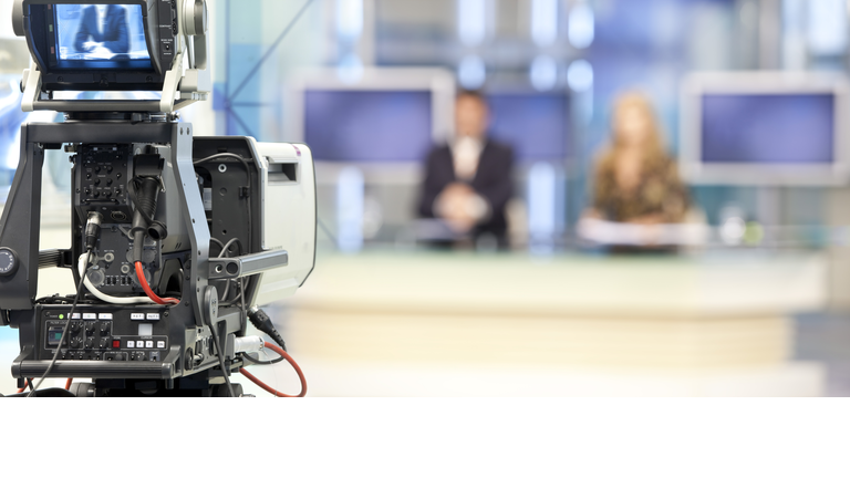 Two newsreader in front of television camera