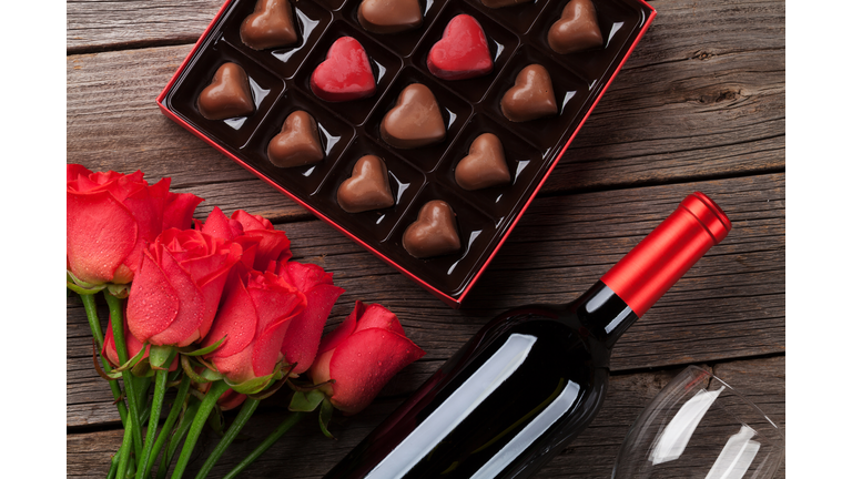 Valentines day with red roses, wine and chocolate