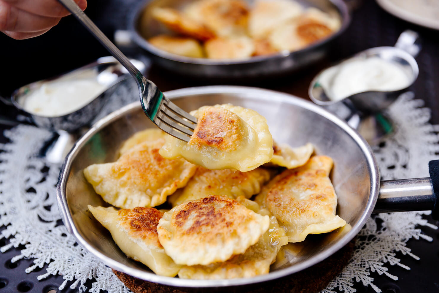 Eating traditional Polish dumplings Pierogi with fork