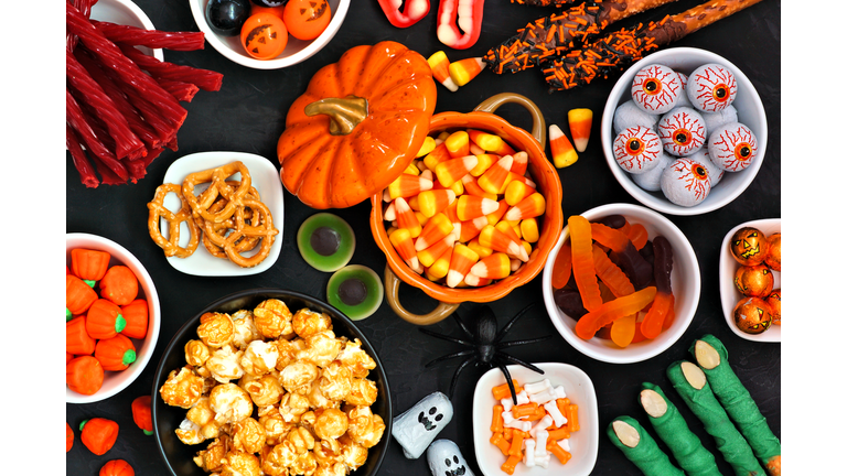 Halloween candy buffet table top view over a black background