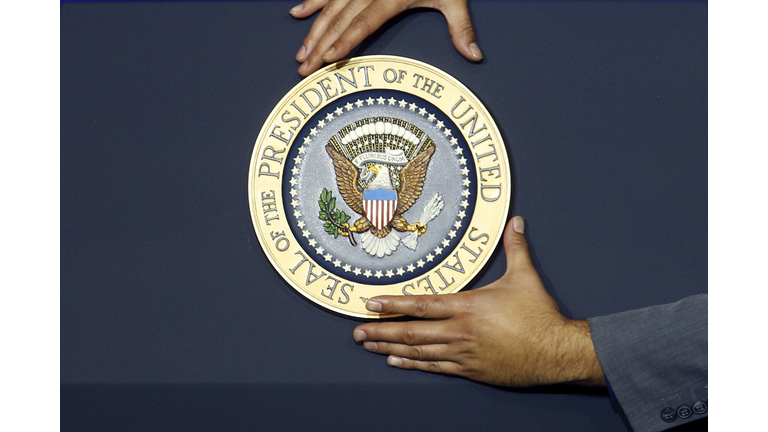 The presidential seal is affixed is affixed to a podium