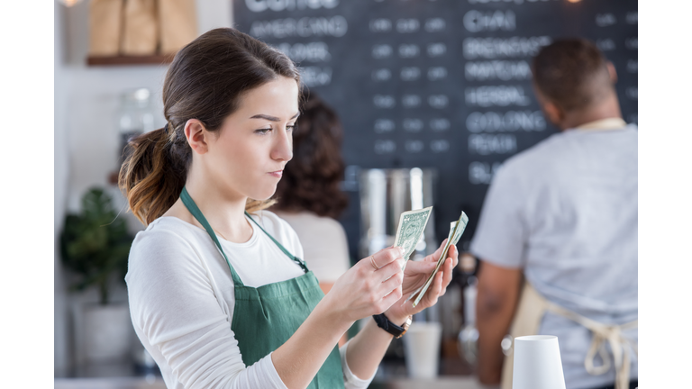 Female barista is disappointed with her tips