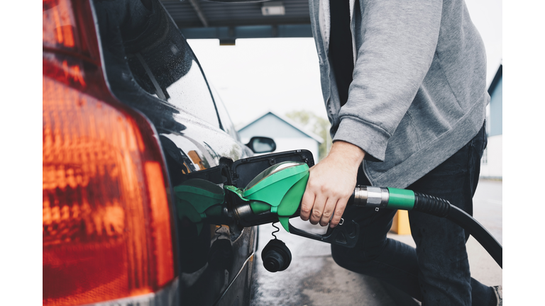 Midsection of man refueling car at gas station