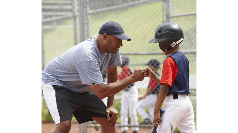 Coach Bumping Fists With Little League Batter