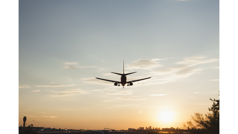 Plane landing with sun setting