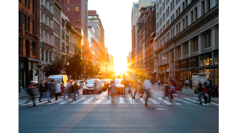Crowds of busy people walking through the intersection of 5th Avenue and 23rd Street in Manhattan, New York City