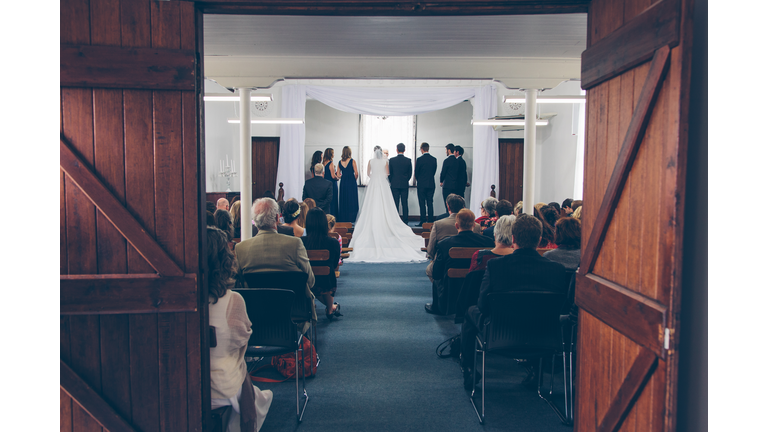 Bridal Party standing on stage in small hall