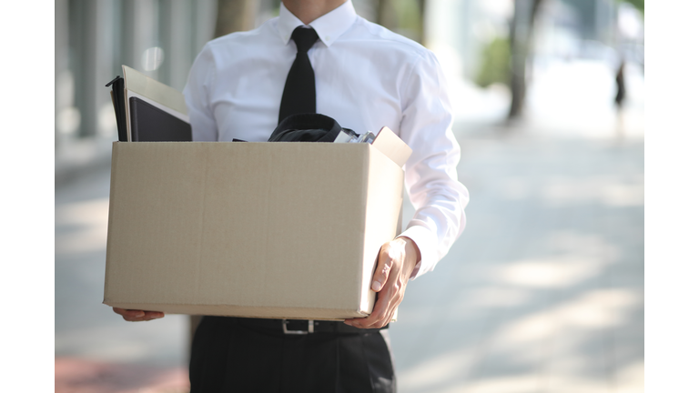 Close-up Of Unemployed Businessperson Carrying Cardboard Box