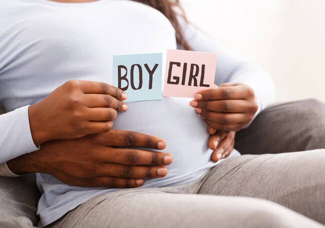 Couple holding pink and blue color card for baby gender
