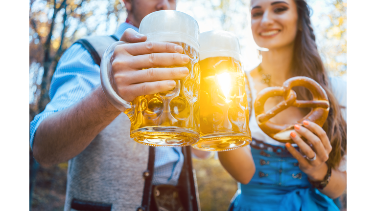 Couple Toasting Beer Glasses While Standing Outdoors