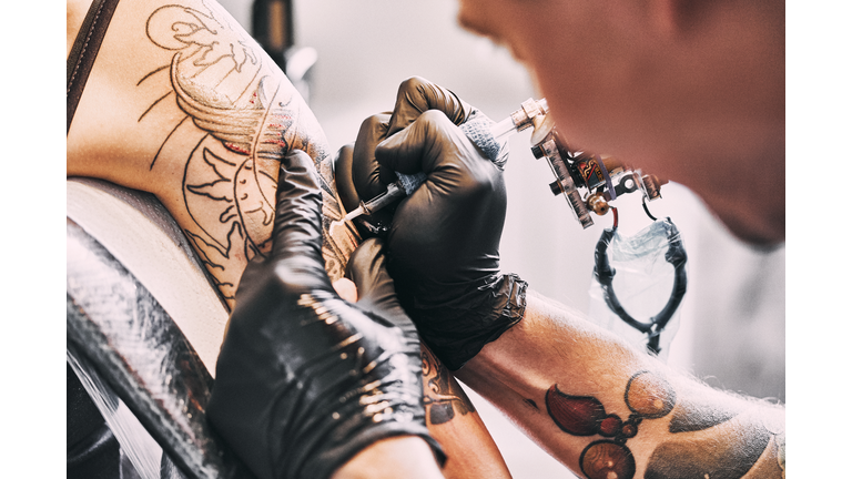 Tattoo Artist making a tattoo on a shoulder