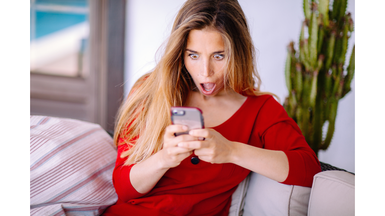 Woman feeling big surprise checking phone