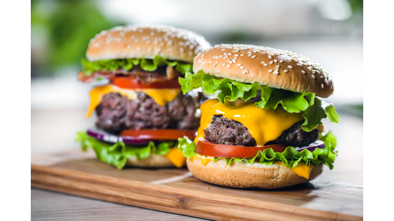 Two Home Made Huge Cheeseburger on oak chopping board