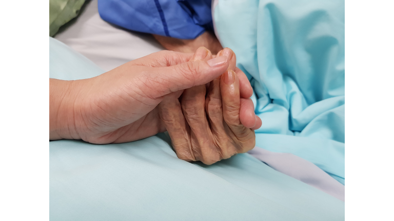 Holding grandmother's hand in the nursing care. Showing all love, empathy, helping and encouragement : healthcare in end of life and palliative concept