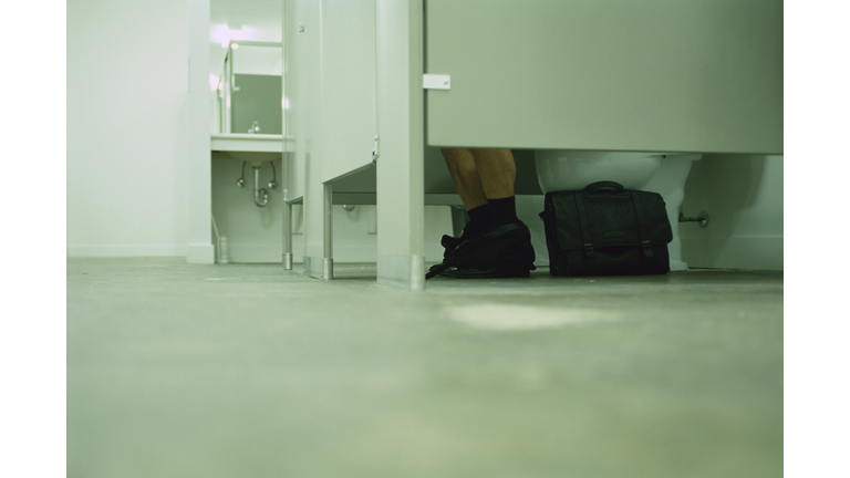 Businessman Using Restroom