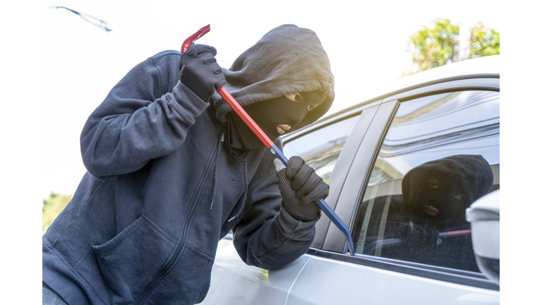 car theft - thief trying to break into the vehicle