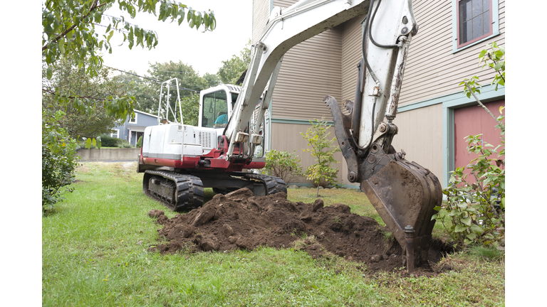 Man digging up oil tank with excavator