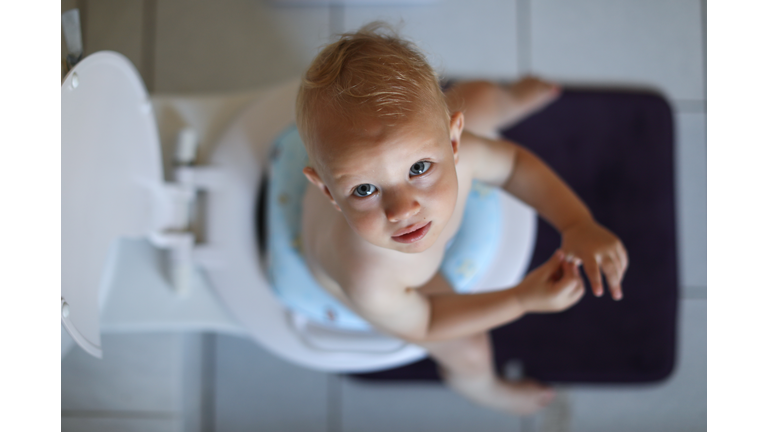 a Baby boy learning how to use the toilet.