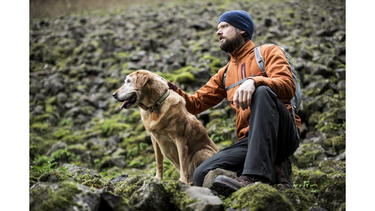 A man hiking with his dog.