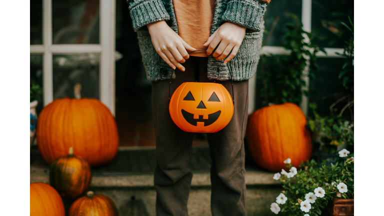boy holding a halloween cup full of candies