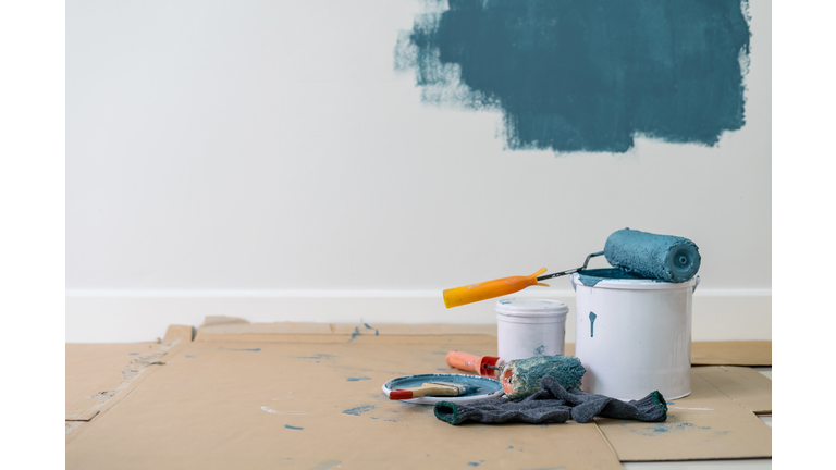 Close-Up Of Paint Roller On Container Against Wall