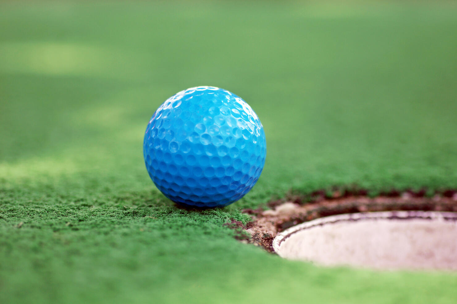 Blue Mini Golf Ball On Grass Near Hole